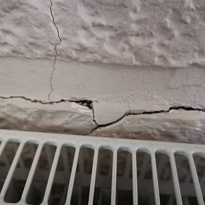 Blown chrysolite plaster behind radiator